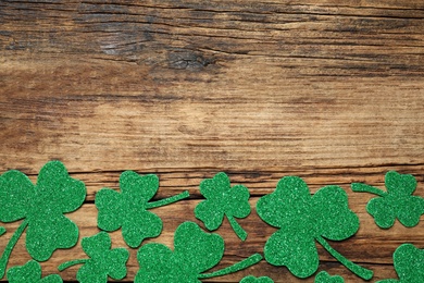 Flat lay composition with clover leaves on wooden background, space for text. St. Patrick's Day celebration