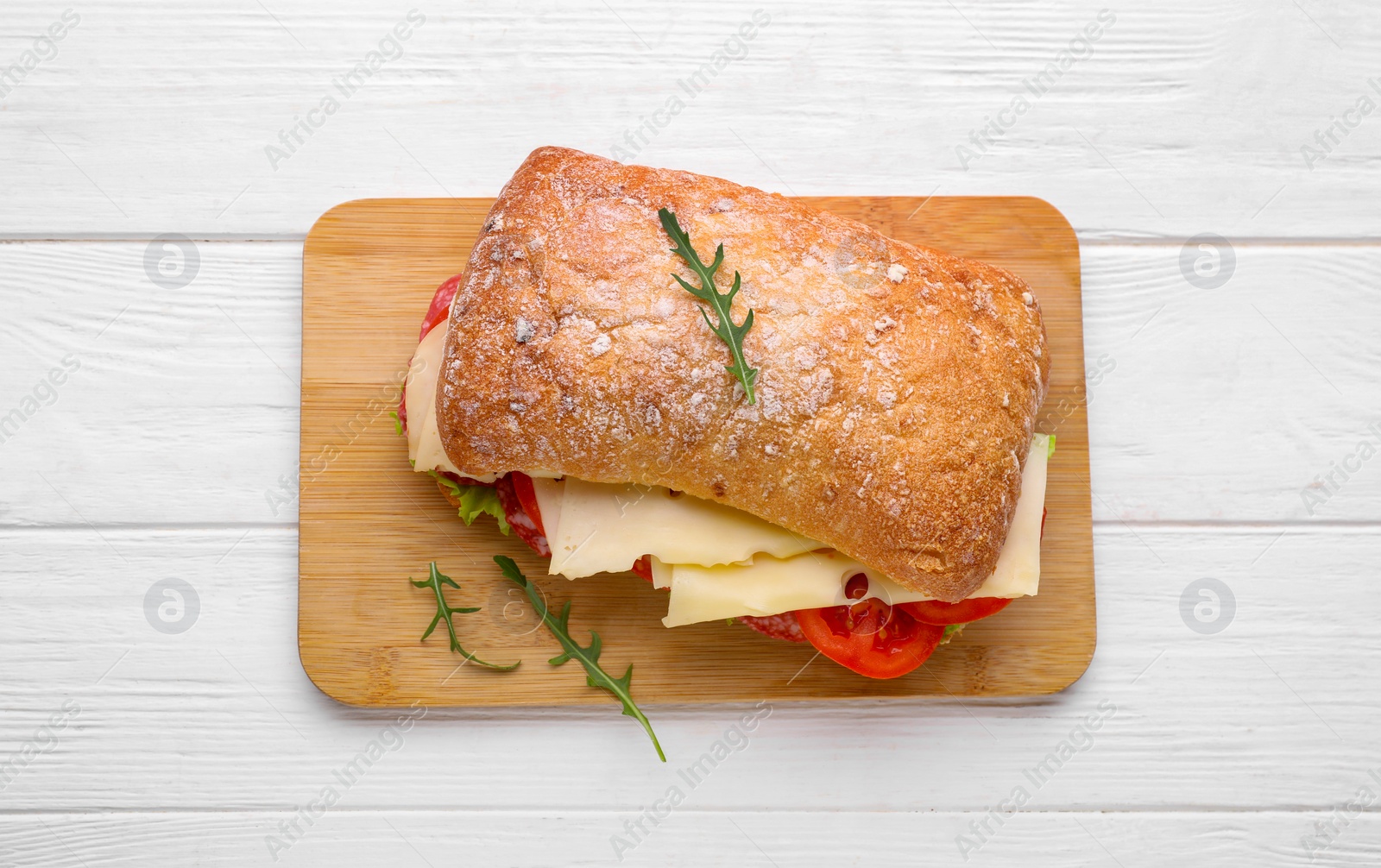 Photo of Delicious sandwich with cheese, salami, tomato on white wooden table, top view
