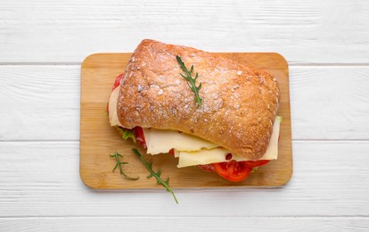 Delicious sandwich with cheese, salami, tomato on white wooden table, top view