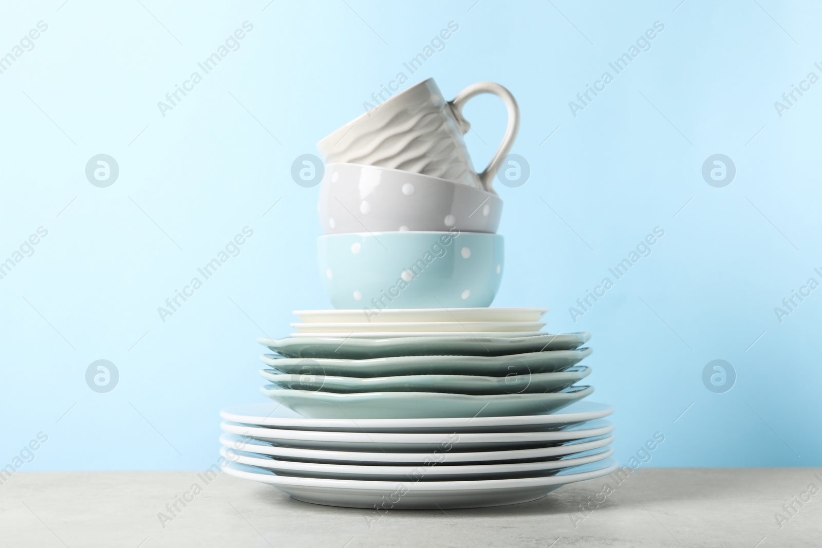 Photo of Beautiful ceramic dishware and cup on light grey table