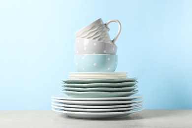 Photo of Beautiful ceramic dishware and cup on light grey table