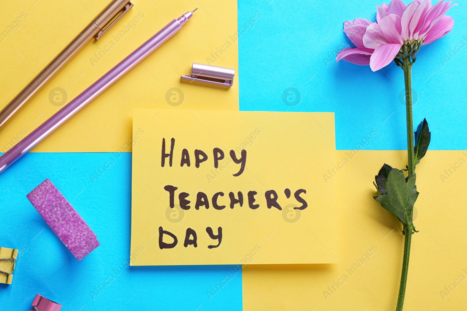 Photo of Paper with inscription HAPPY TEACHER'S DAY and stationery on color background