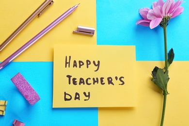 Paper with inscription HAPPY TEACHER'S DAY and stationery on color background