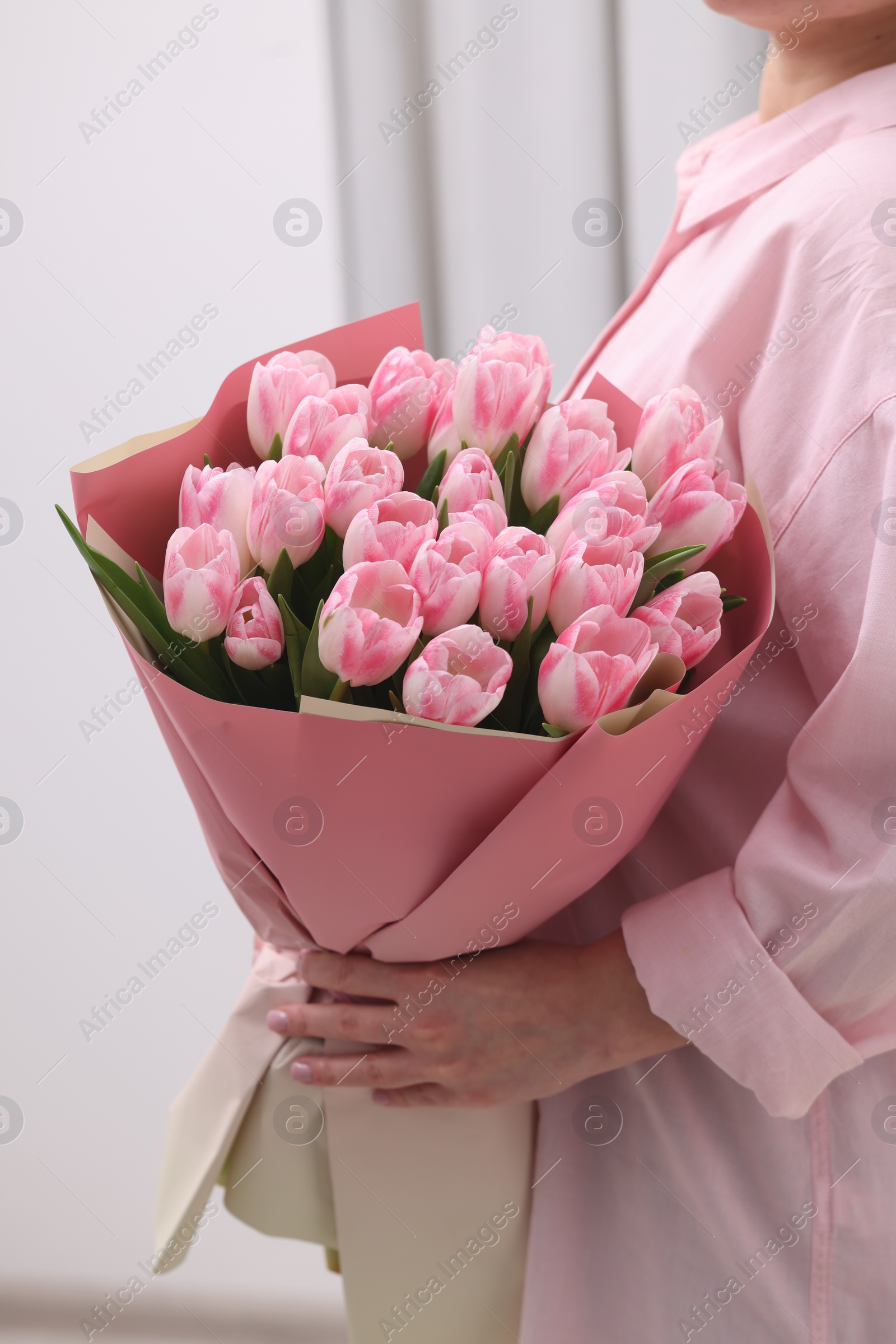 Photo of Woman with bouquet of beautiful fresh tulips on blurred background, closeup