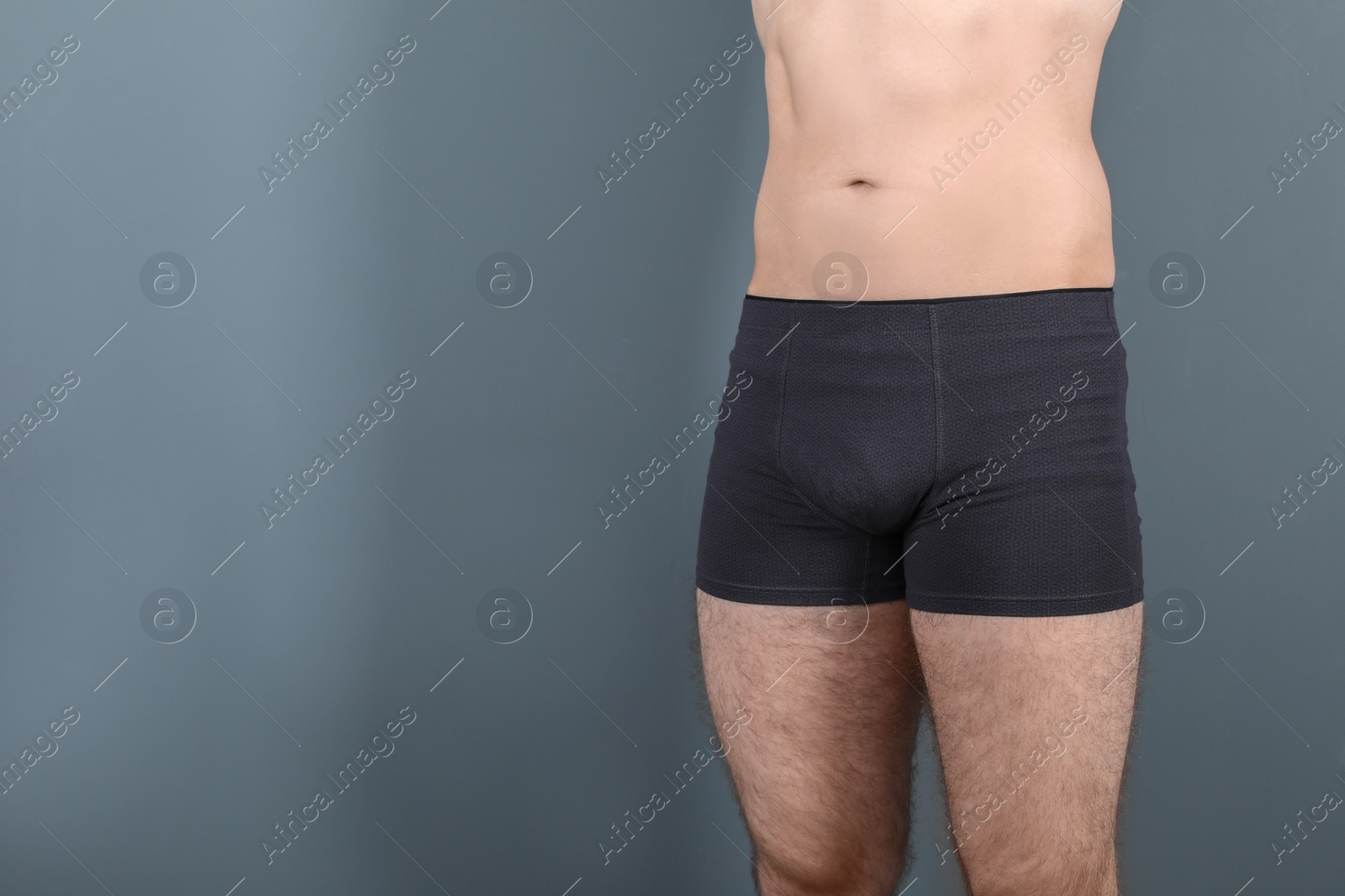 Photo of Attractive young man in underwear on grey background