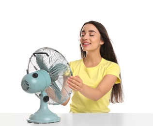 Photo of Woman enjoying air flow from fan on white background. Summer heat