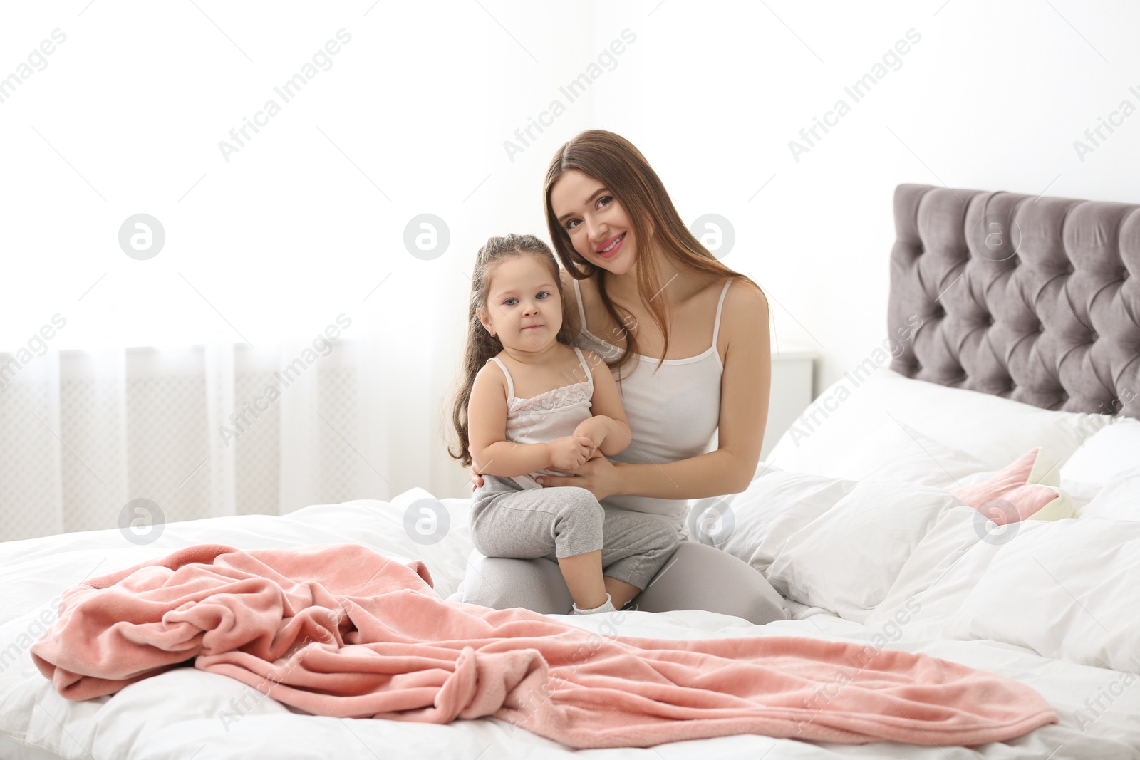 Photo of Happy mother with little daughter in bedroom