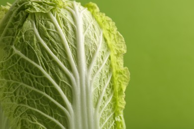 Photo of Fresh ripe Chinese cabbage on light green background, closeup. Space for text