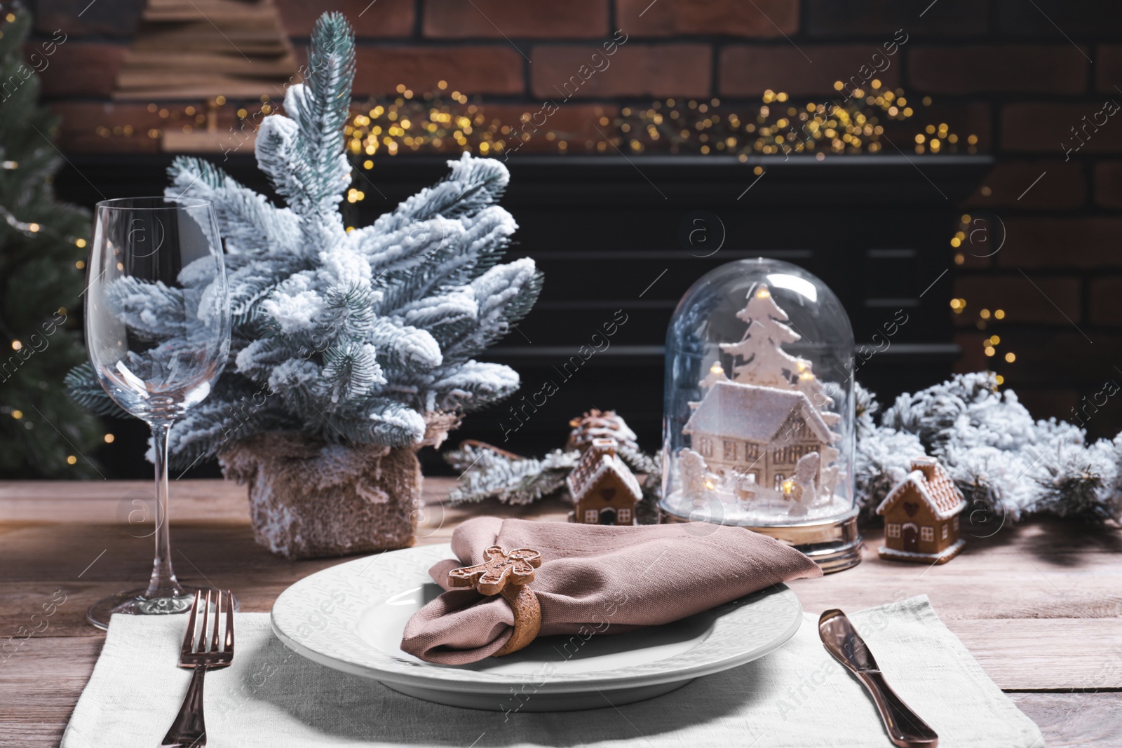 Photo of Plate with fabric napkin, cutlery and festive decor on wooden table