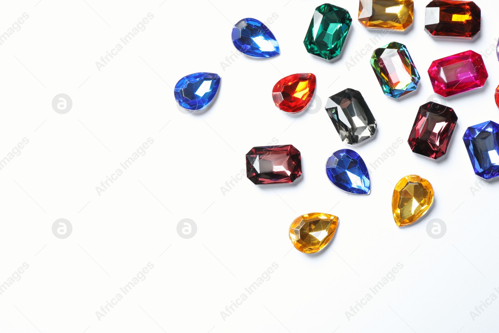 Photo of Different beautiful gemstones on white background, top view