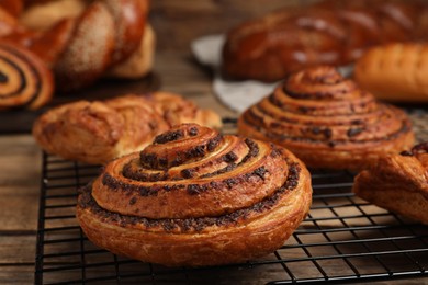 Photo of Freshly baked spiral bun and other pastries on table, closeup
