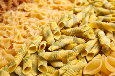 Photo of Different types of pasta as background, closeup