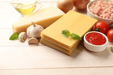 Ingredients for lasagna on white wooden table