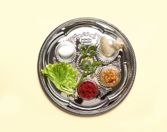 Photo of Traditional silver plate with symbolic meal for Passover (Pesach) Seder on color background, top view
