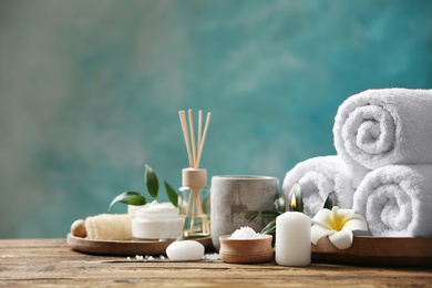 Photo of Beautiful spa composition with towels on wooden table against light blue background