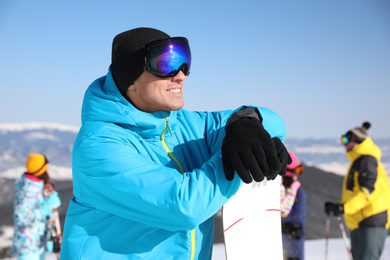 Man with snowboard at ski resort. Winter vacation