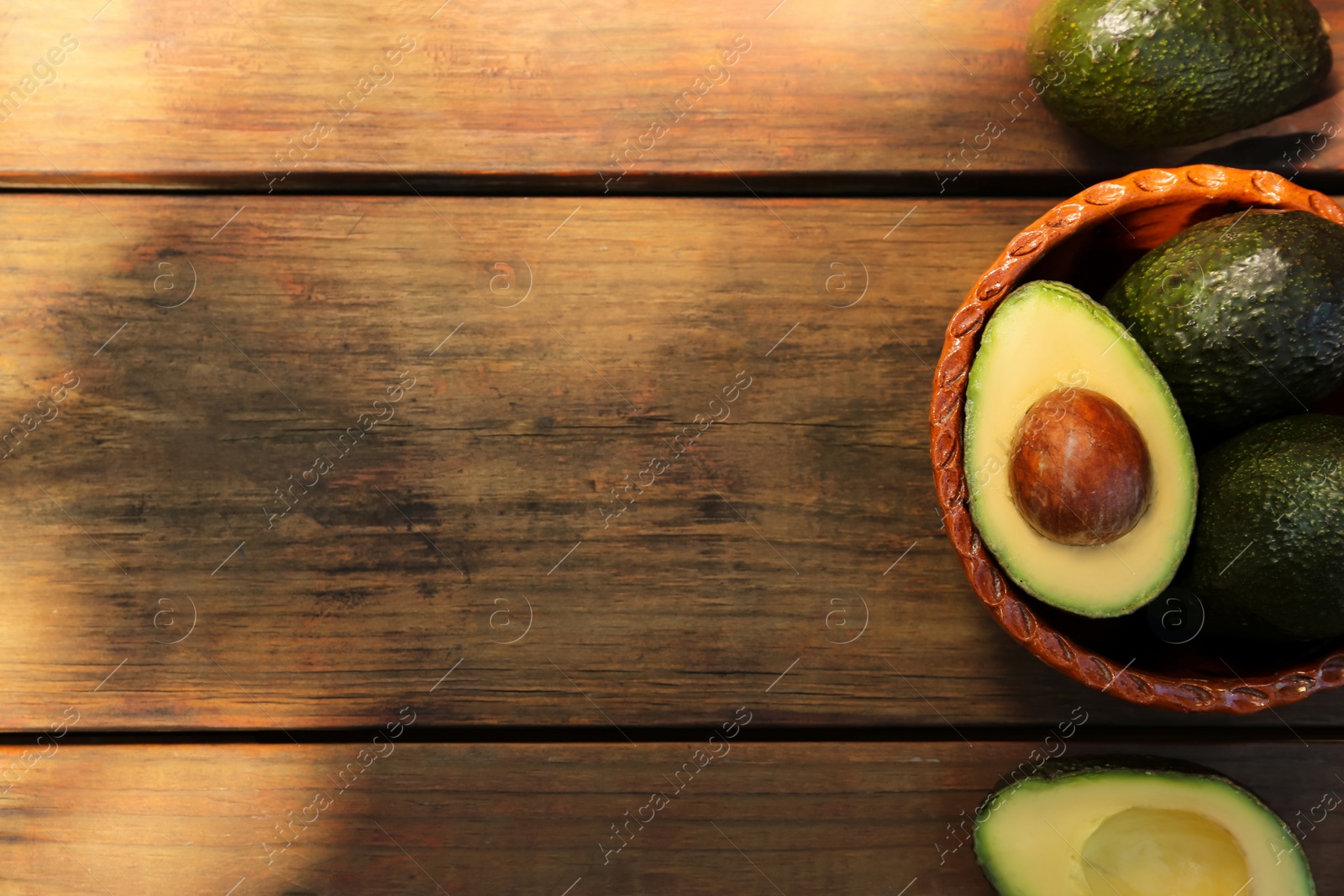 Photo of Tasty fresh avocados on wooden table, top view. Space for text
