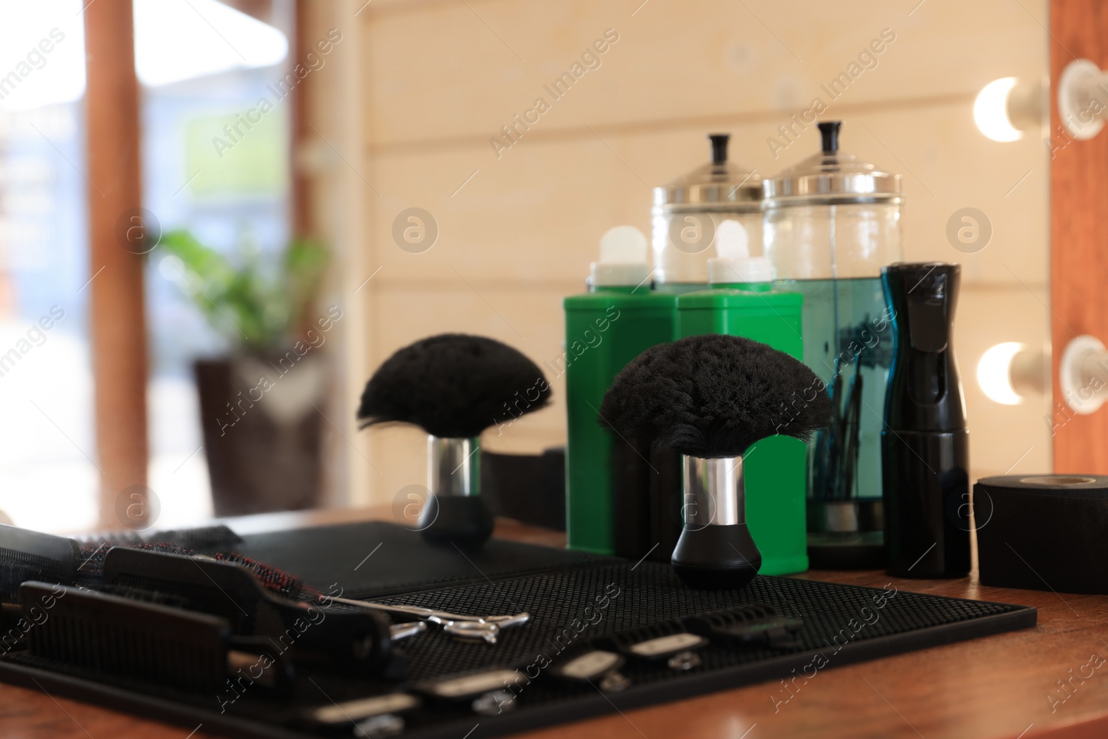 Photo of Stylish hairdresser's workplace with professional tools and cosmetic products in barbershop