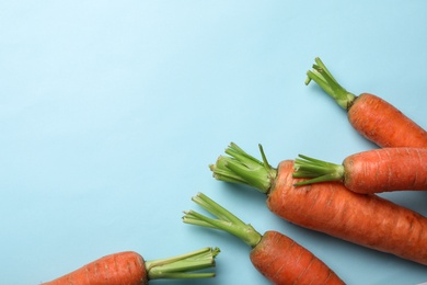 Flat lay composition with fresh carrots on color background. Space for text