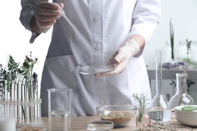 Photo of Scientist developing herbal cosmetic product in laboratory, closeup