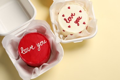 Photo of Bento cakes in takeaway boxes on beige table, flat lay. Space for text. St. Valentine's day surprise