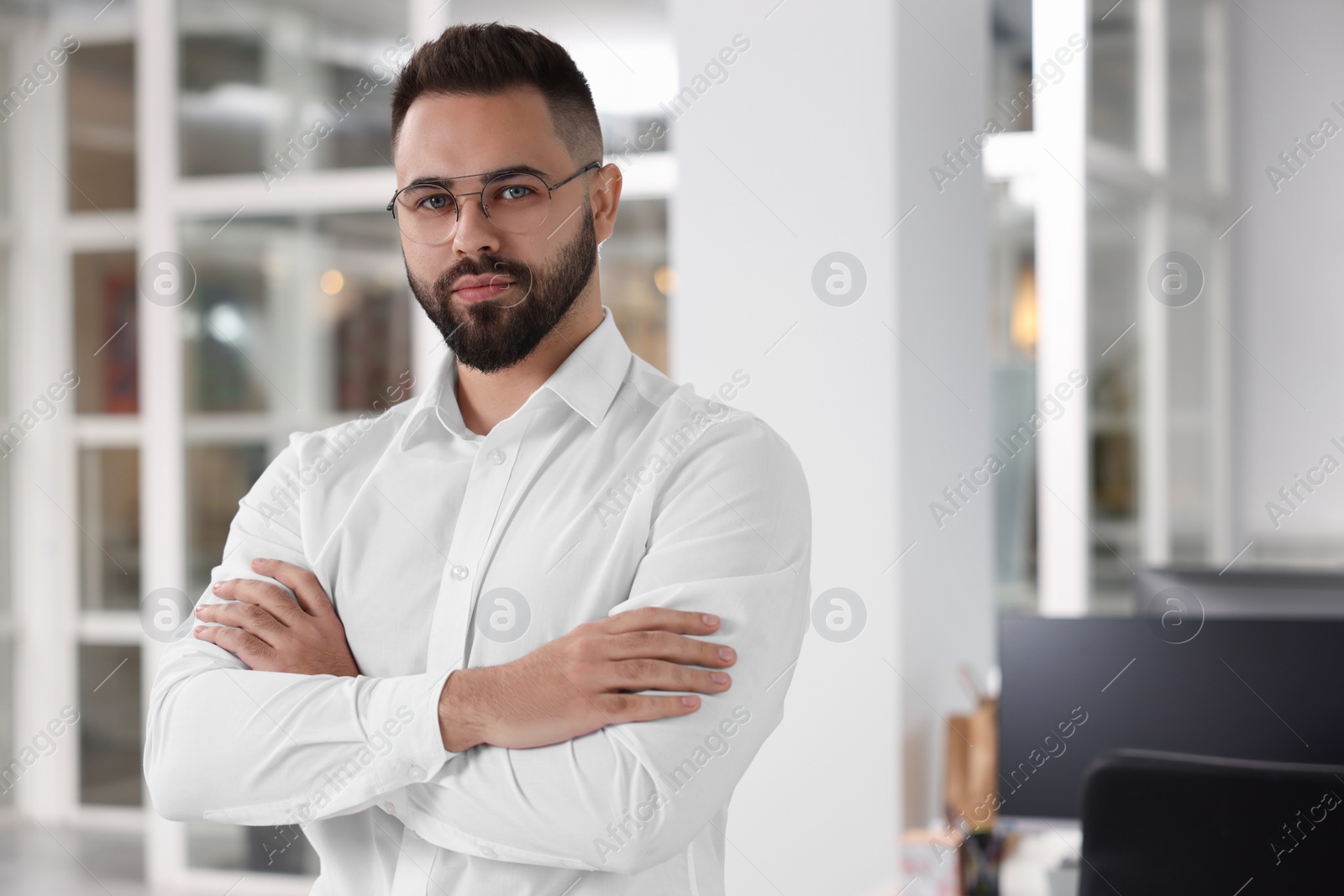 Photo of Portrait of handsome man with crossed arms in office, space for text. Lawyer, businessman, accountant or manager