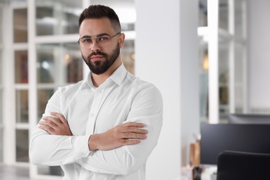 Photo of Portrait of handsome man with crossed arms in office, space for text. Lawyer, businessman, accountant or manager