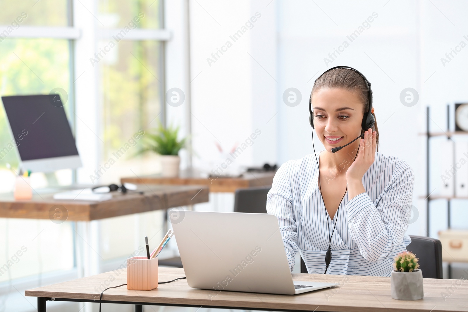 Photo of Female receptionist with headset at desk in office