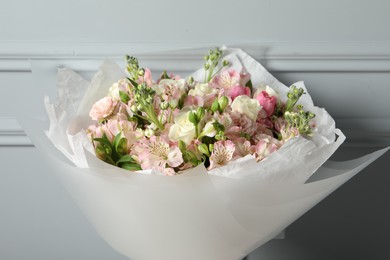 Photo of Beautiful bouquet of fresh flowers near grey wall