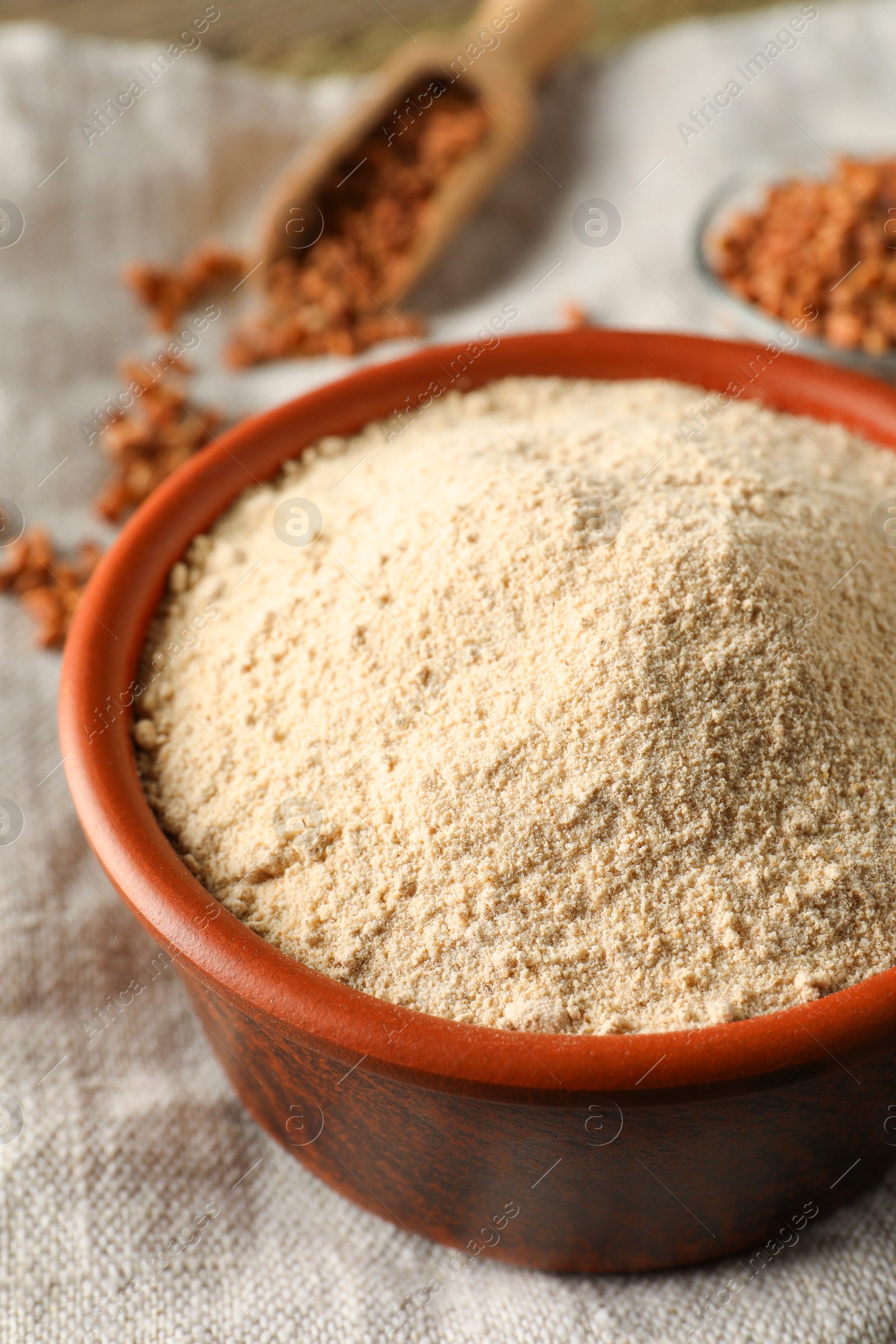 Photo of Bowl of buckwheat flour on cloth, closeup