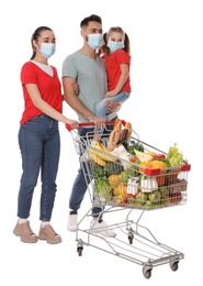 Family with protective masks and shopping cart full of groceries on white background