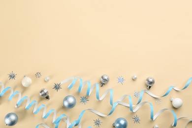 Photo of Flat lay composition with serpentine streamers and Christmas decor on beige background. Space for text