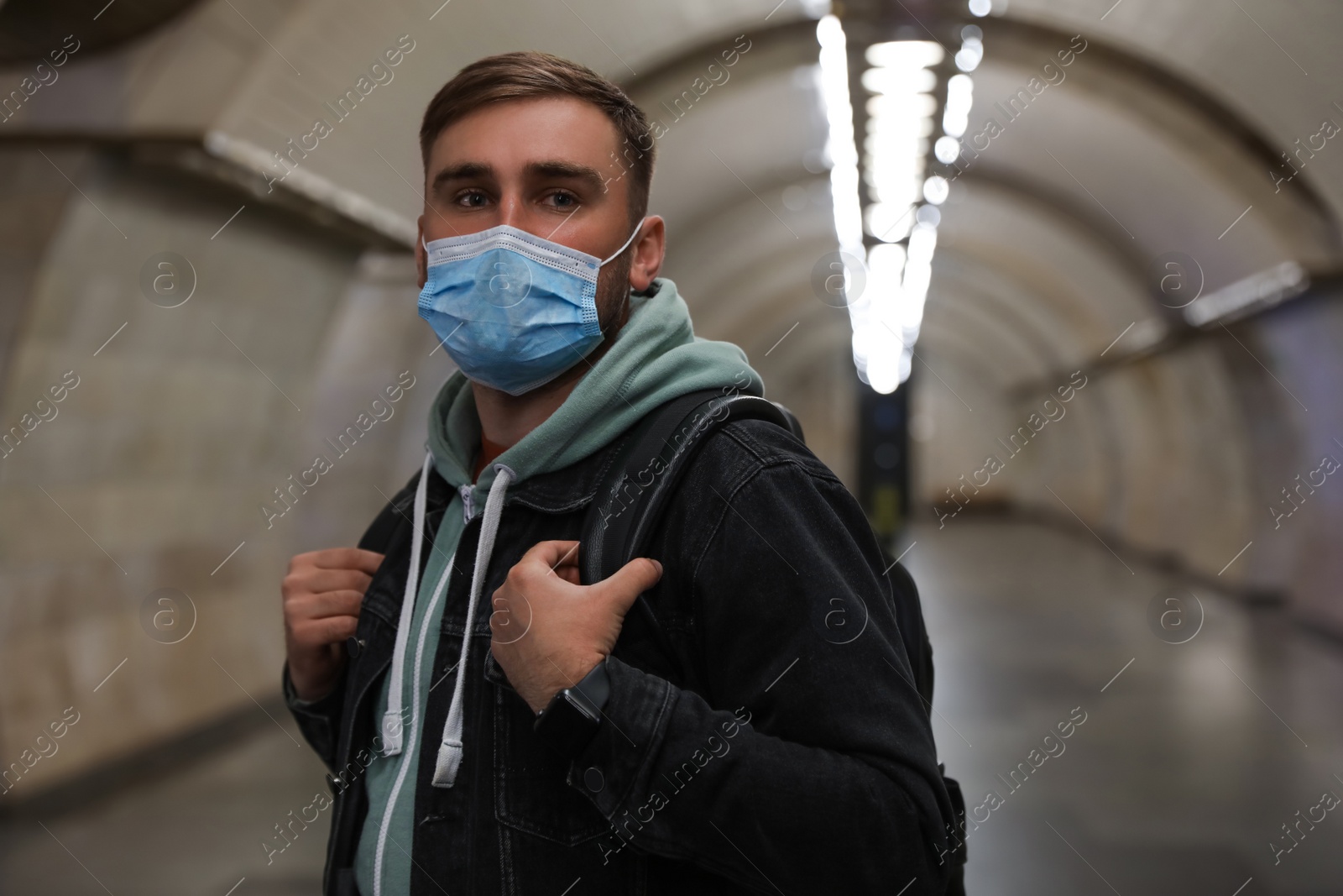 Photo of Young man in protective mask at subway station. Public transport