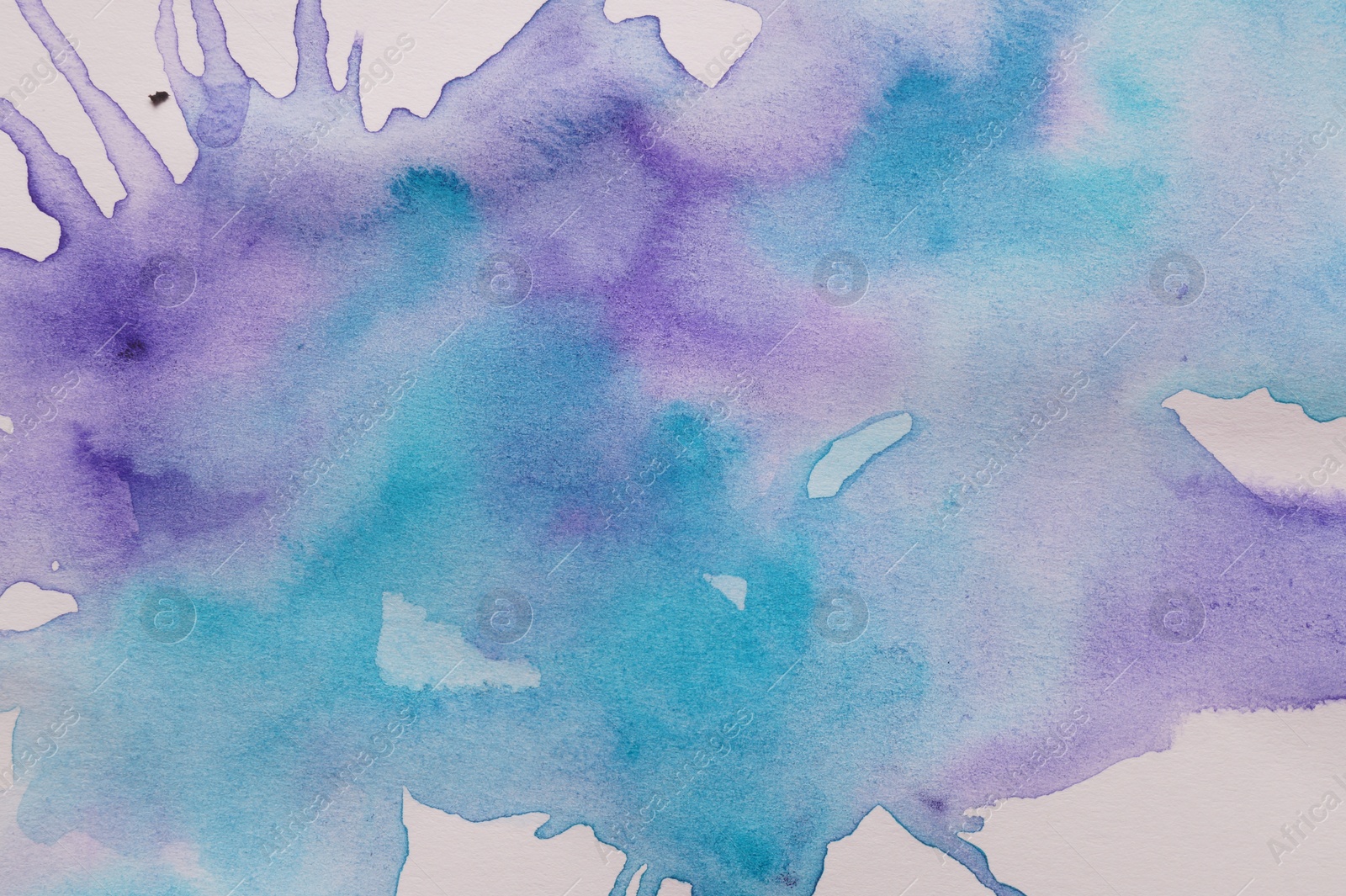 Photo of Abstract blue and purple watercolor paint on white canvas, top view