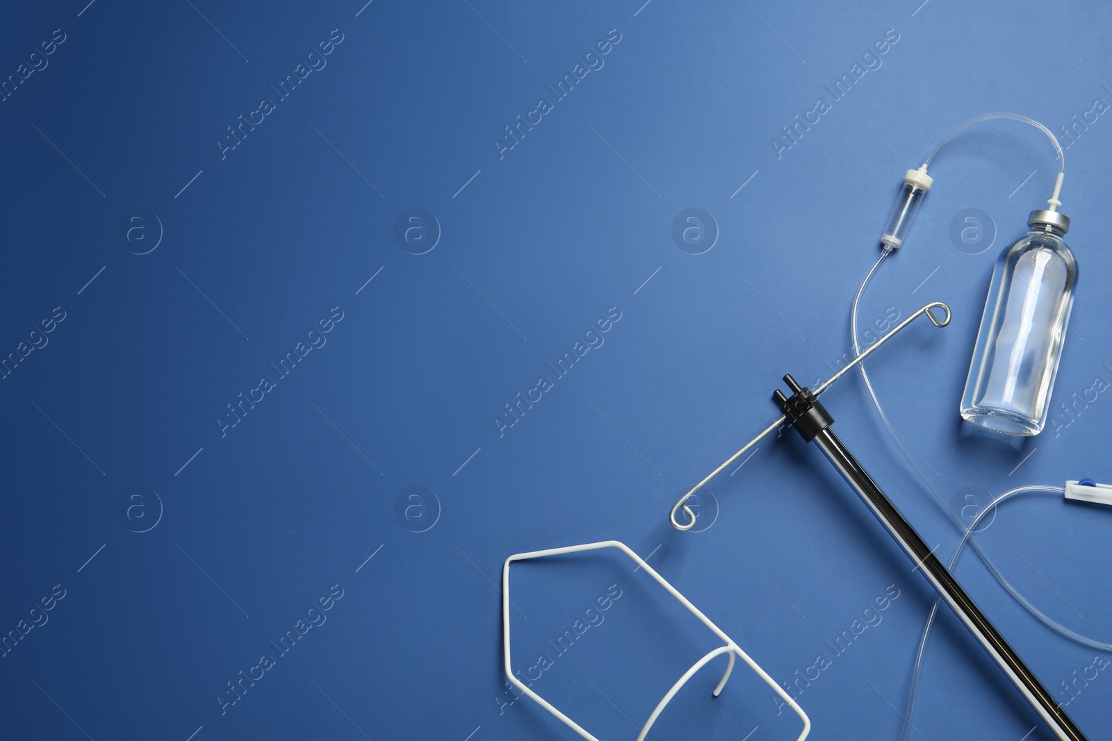 Photo of IV infusion set on blue background, flat lay. Space for text