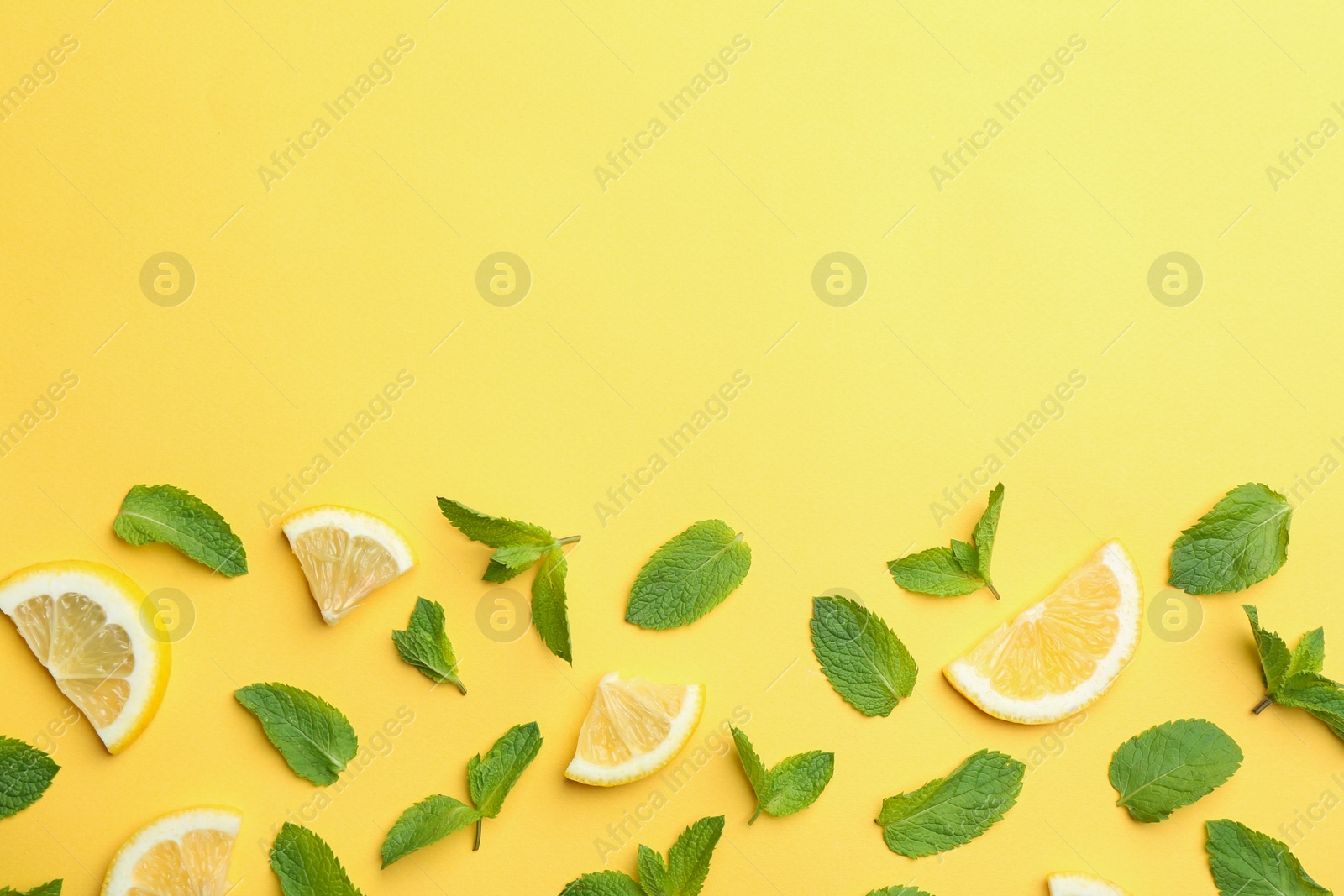 Photo of Fresh mint with sliced lemon on yellow background, flat lay. Space for text