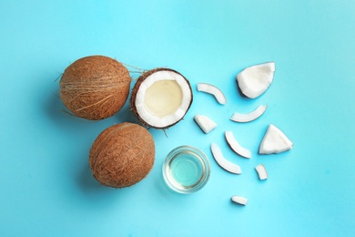 Photo of Flat lay composition with ripe coconuts and natural organic oil on blue background