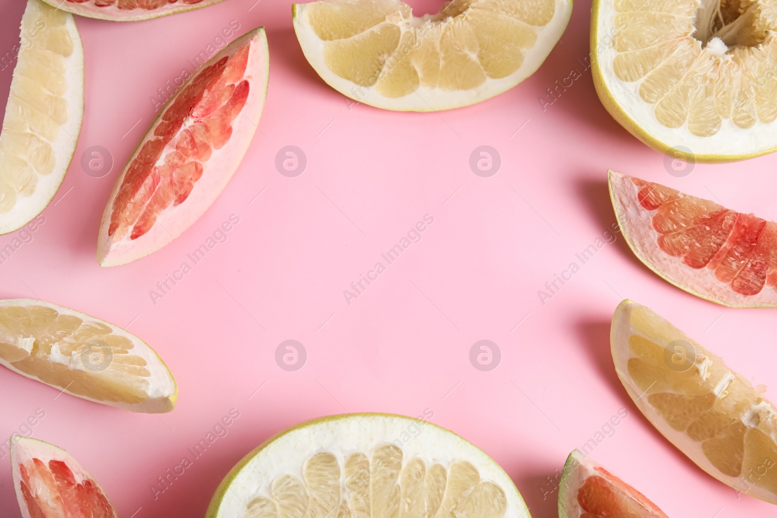 Photo of Frame made of different ripe pomelos on pink background, flat lay. Space for text