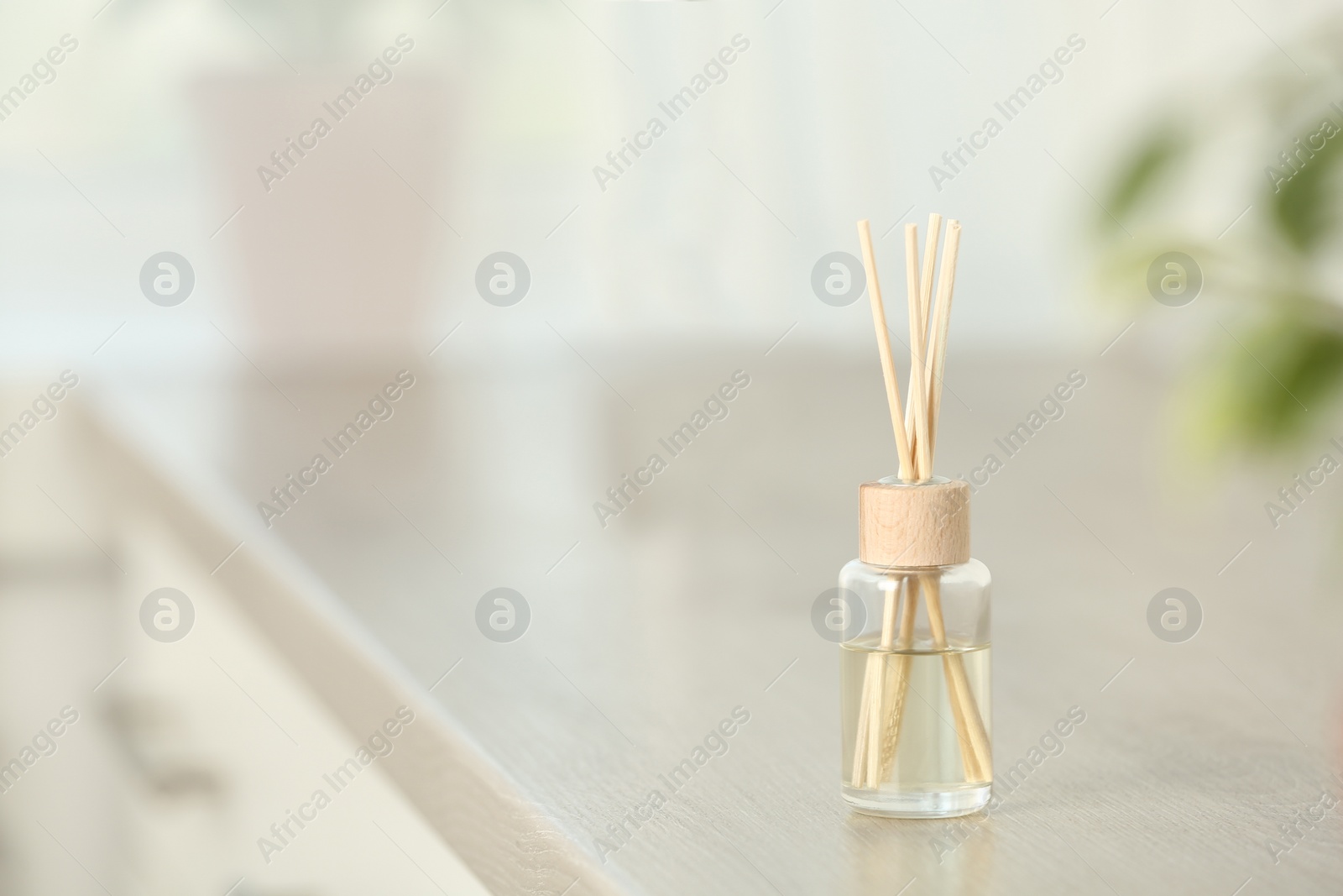 Photo of Reed air freshener on table indoors, space for text