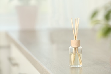 Reed air freshener on table indoors, space for text