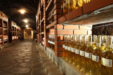 Photo of Beregove, Ukraine - June 23, 2023: Many bottles of alcohol drinks on shelves in cellar