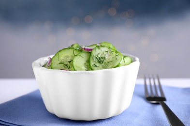 Bowl of tasty cucumber salad on table