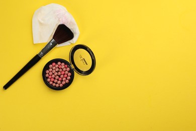 Photo of Dirty tissue, blush and brush on yellow background, flat lay. Space for text