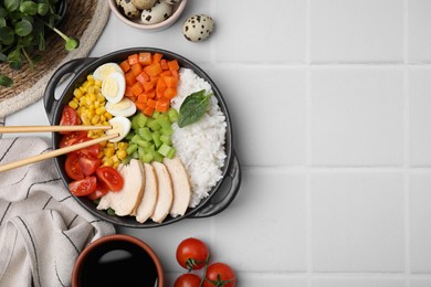 Photo of Delicious poke bowl with meat, egg, rice and vegetables on white tiled table, flat lay. Space for text