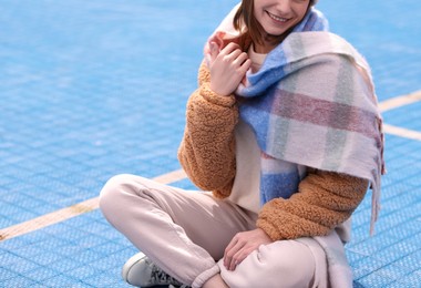 Photo of Stylish woman in warm scarf outdoors, closeup