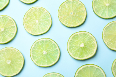 Photo of Fresh juicy lime slices on light blue background, flat lay