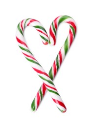 Photo of Heart shape made of sweet Christmas candy canes on white background