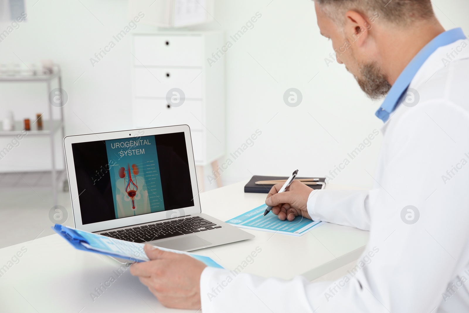 Photo of Mature urologist working at table in hospital