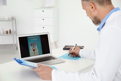 Mature urologist working at table in hospital