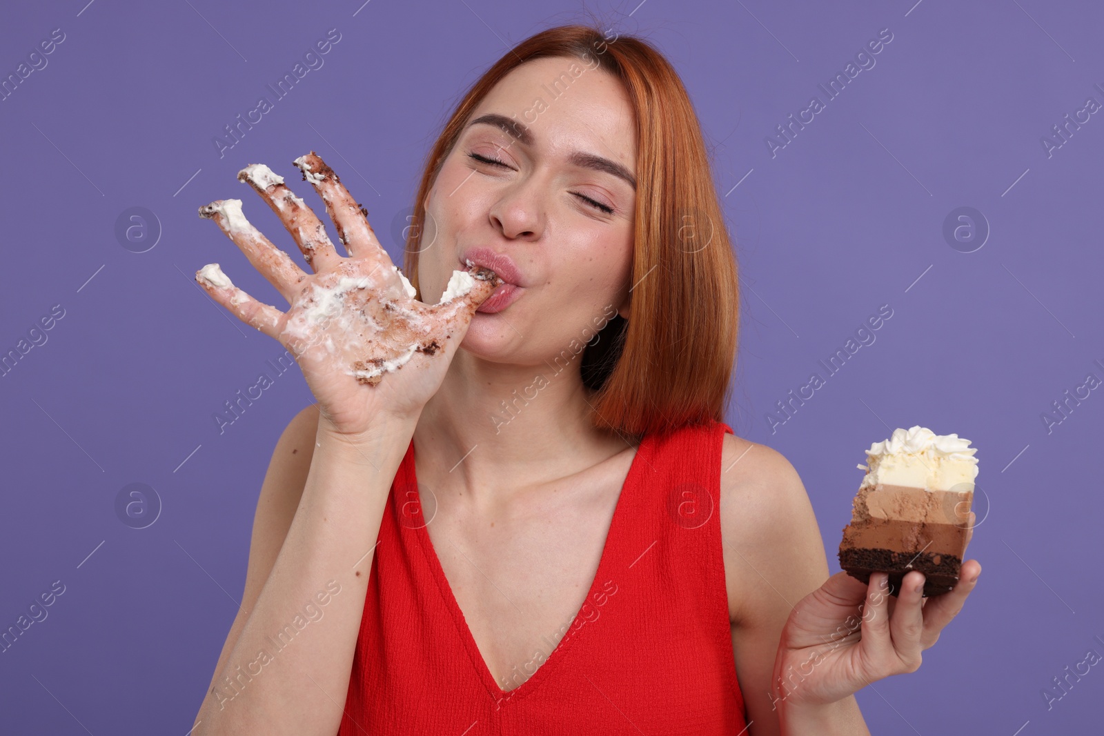 Photo of Young woman eating piece of tasty cake on purple background